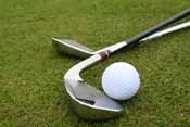 golf clubs laying on putting green